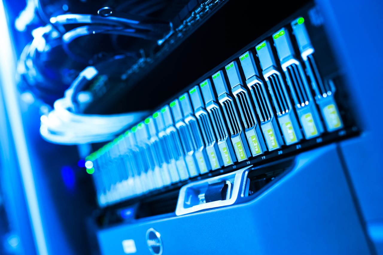 services-03 A detailed view of a blue lit computer server rack in a data center showcasing technology and hardware.